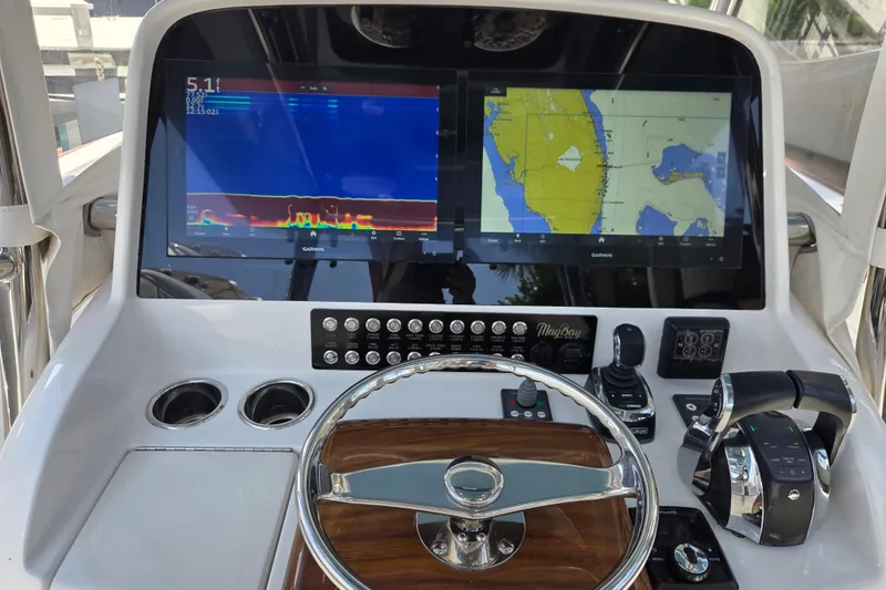 Slide: The Image of 2019 Mag Bay 33 CC boat dashboard with Garmin navigation displays and controls. - 8