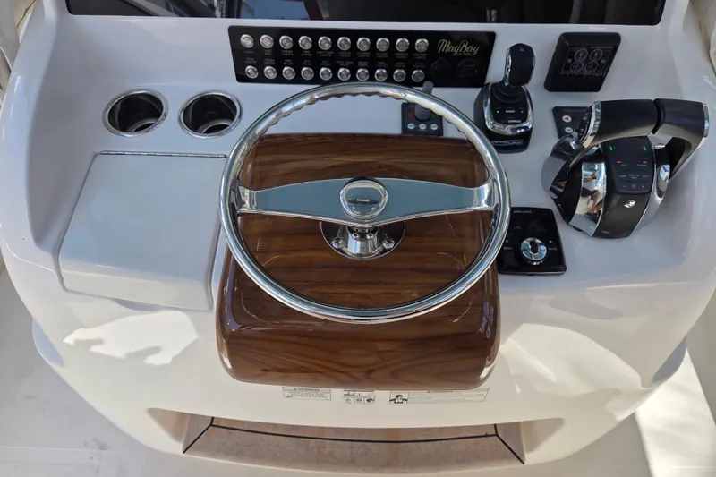Slide: The Image of 2019 Mag Bay 33 CC helm with steering wheel, controls, and cup holders. - 9