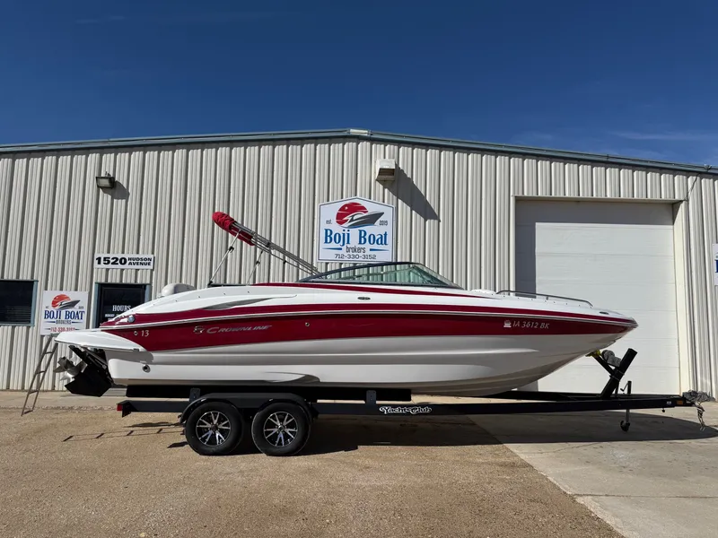The Image of 2012 Crownline 252 EX boat on trailer outside warehouse. - 0