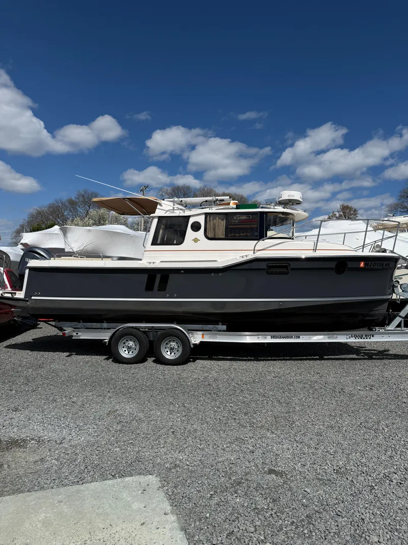 The Image of 2023 Ranger Tugs R-25 boat on trailer under blue sky with clouds. - 1