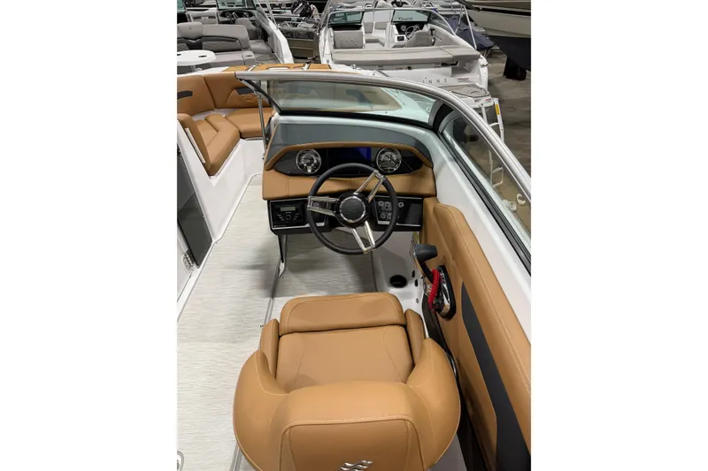 Slide: The Image of 2025 Four Winns HD3 boat interior with tan leather seats and modern dashboard. - 12