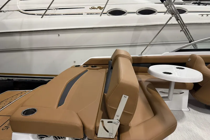 Slide: The Image of 2025 Four Winns HD3 boat interior with tan seating and white table. - 13