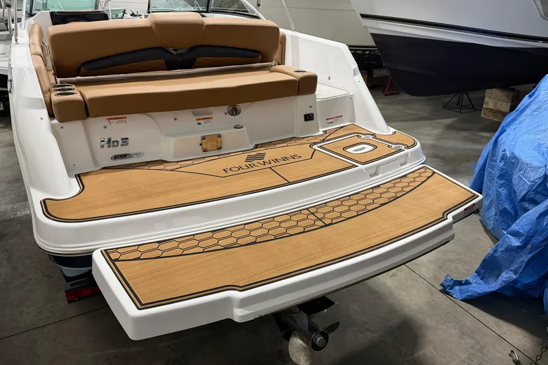 Slide: The Image of 2025 Four Winns HD3 boat with tan seating and teak-style swim platform. - 16