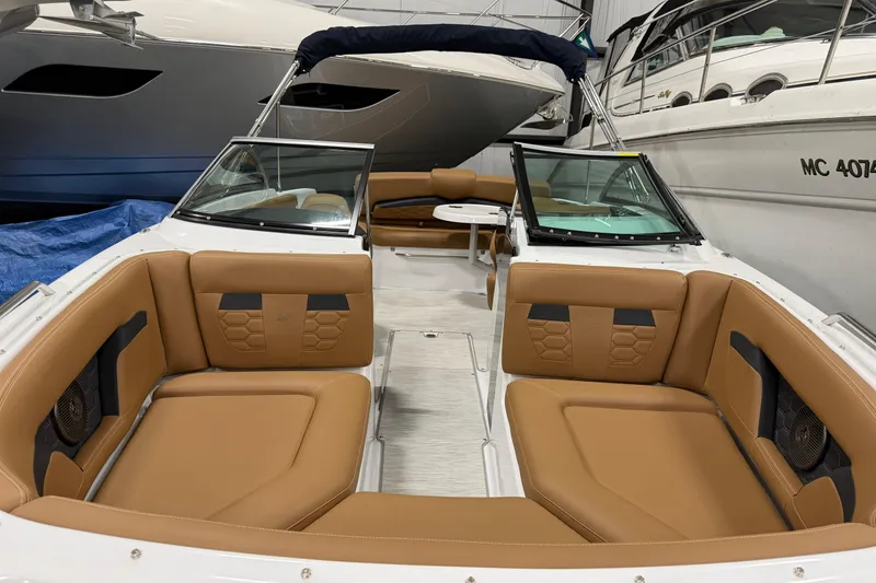 Slide: The Image of 2025 Four Winns HD3 boat interior with tan leather seating in a showroom. - 8