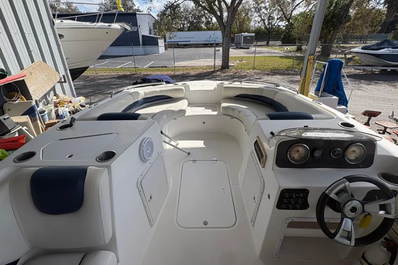 Slide: The Image of 2014 Hurricane SunDeck 187 OB boat interior with seating and steering wheel in a storage area. - 4