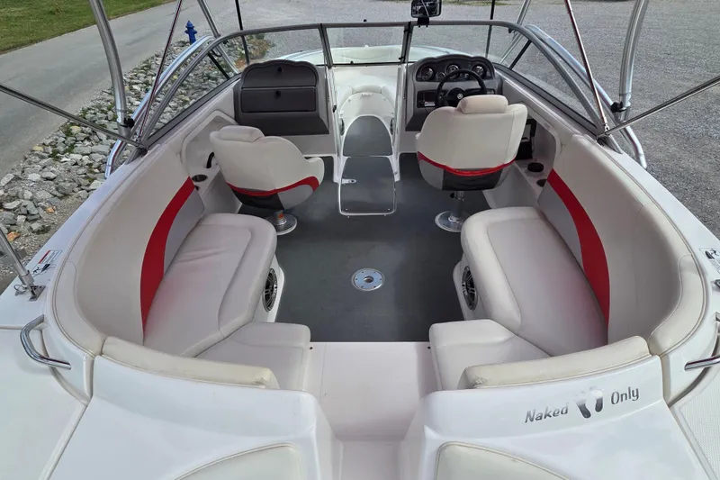 Slide: The Image of 2005 Yamaha AR230 boat interior with white and red seating, steering wheel, and open deck. - 4
