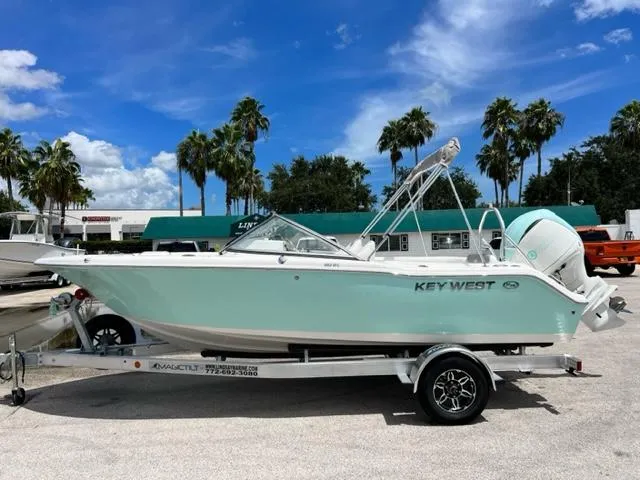 The Image of 2024 Key West 203 DFS boat on trailer, palm trees in background. - 1