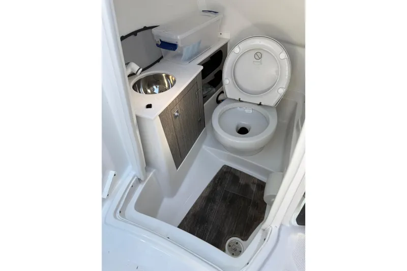 Slide: The Image of 2020 Monterey 255SS Super Sport boat bathroom with toilet, sink, and storage cabinet. - 12
