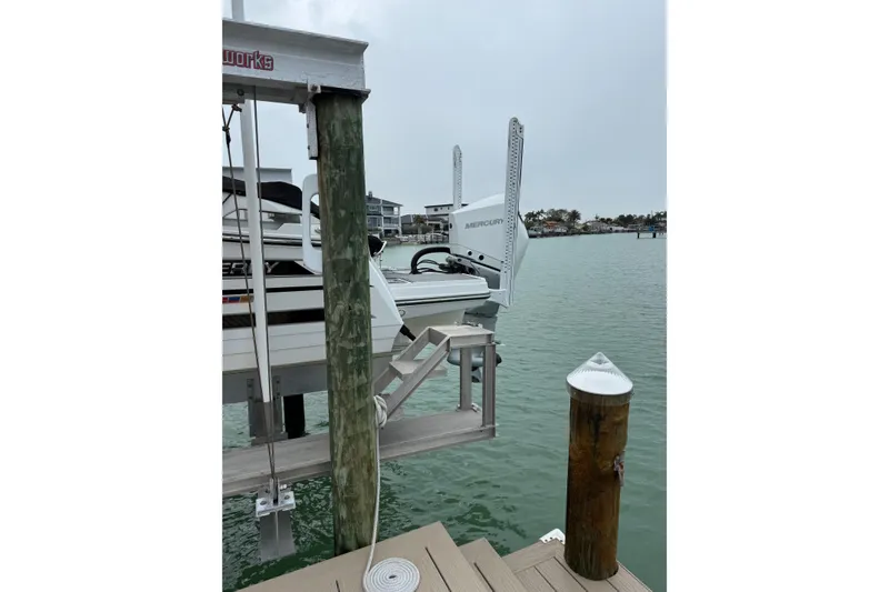 Slide: The Image of 2020 Monterey 255SS Super Sport boat docked on a lift by the water. - 2