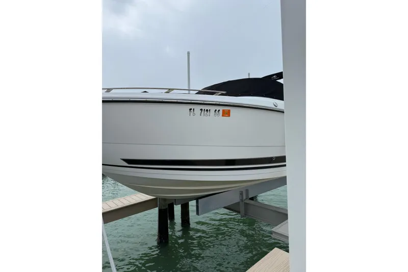 Slide: The Image of 2020 Monterey 255SS Super Sport boat on lift, docked by the water. - 3