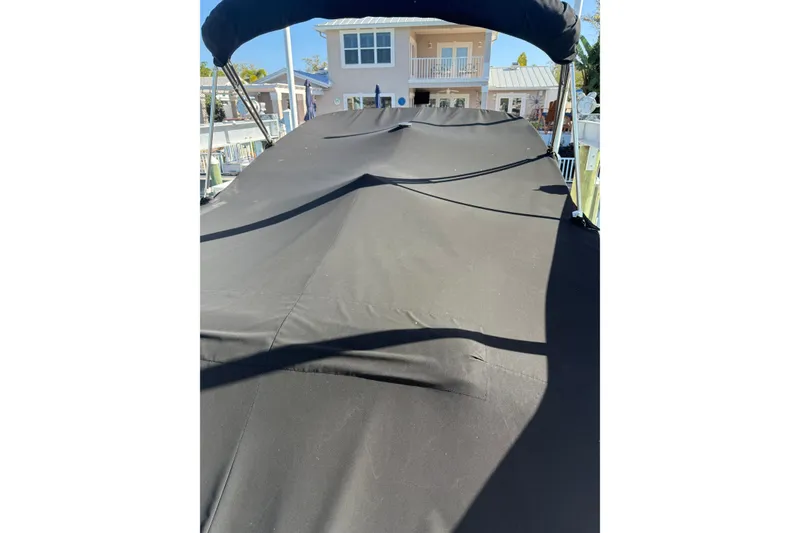 Slide: The Image of 2020 Monterey 255SS Super Sport boat with black cover, docked near a house. - 5