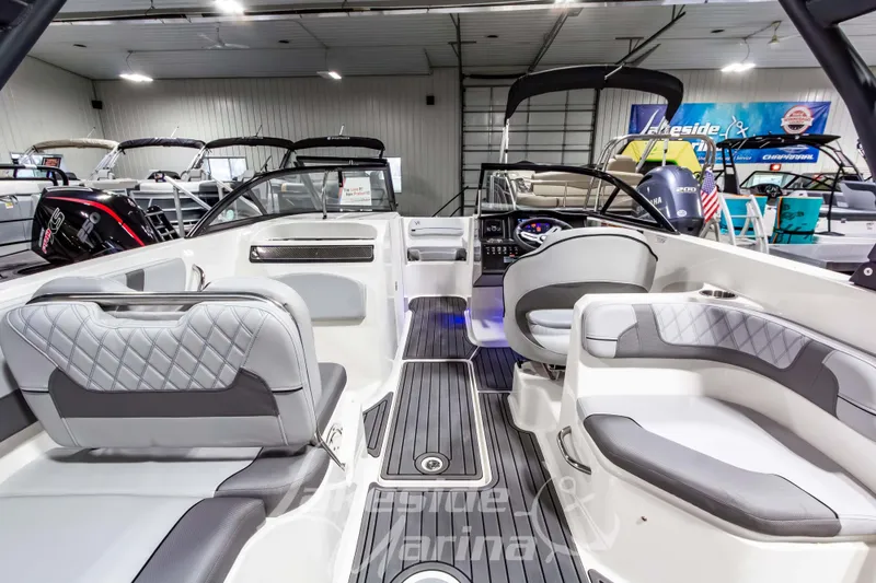 Slide: The Image of 2023 Bayliner VR6 Bowrider I/O interior with modern seating and dashboard in showroom. - 19