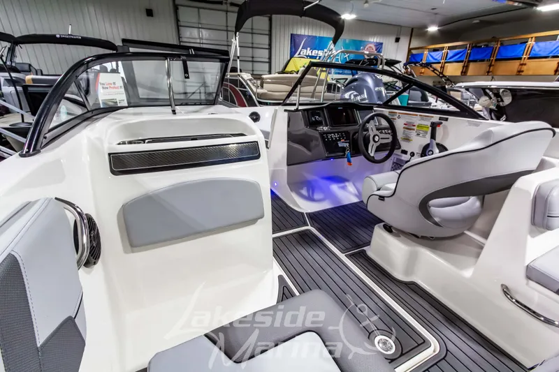 Slide: The Image of 2023 Bayliner VR6 Bowrider I/O interior with modern dashboard and seating in showroom. - 25