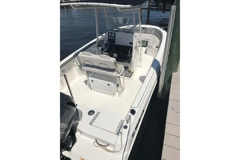 Slide: The Image of 2019 Wellcraft 202 Fisherman boat docked, featuring a spacious deck and modern console. - 17