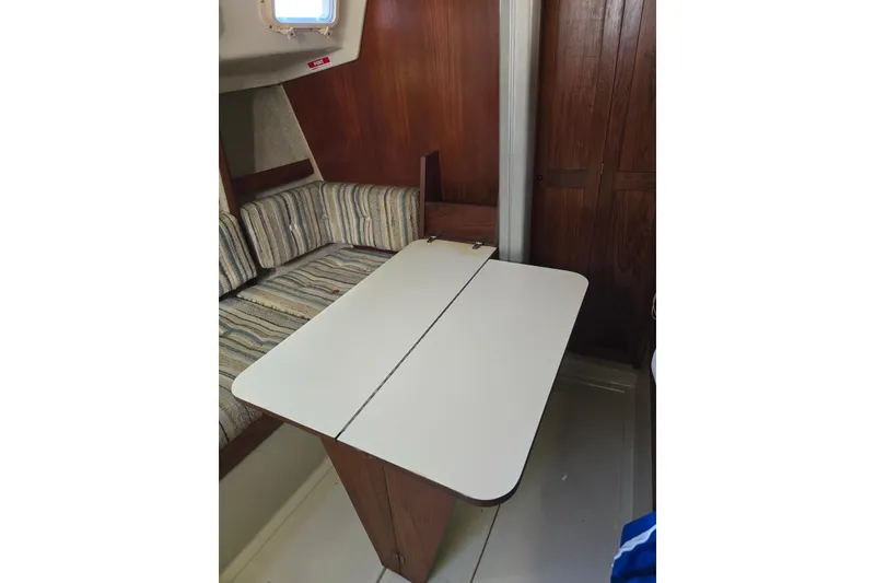 Slide: The Image of Interior of 1982 O'Day 28 sailboat with foldable table and striped seating. - 14
