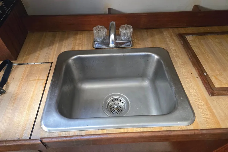 Slide: The Image of Stainless steel sink in 1982 O'Day 28 sailboat galley with wooden countertop. - 21