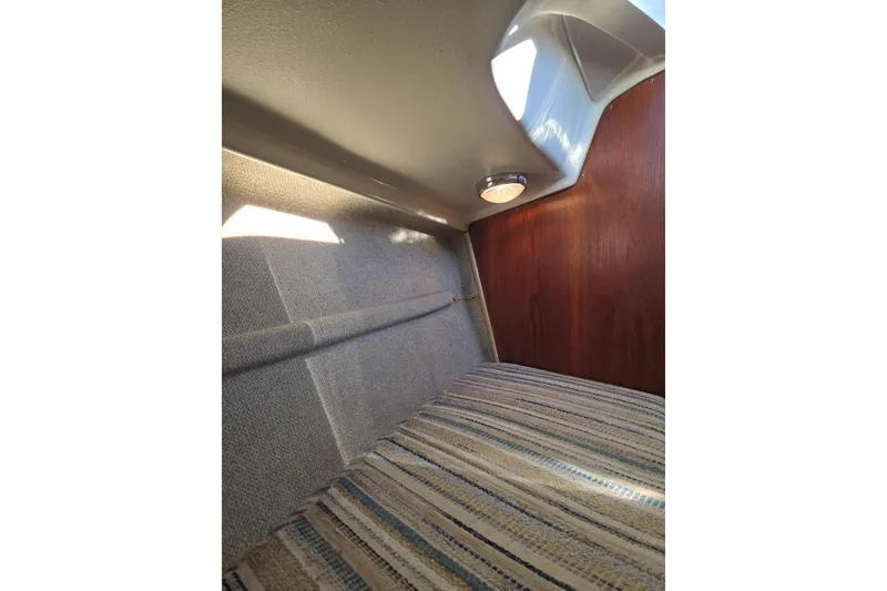Slide: The Image of Interior cabin of 1982 O'Day 28 sailboat with striped upholstery and wooden paneling. - 27