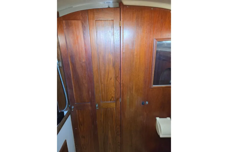 Slide: The Image of Interior wooden cabinetry of 1982 O'Day 28 sailboat, featuring a small window and storage. - 32