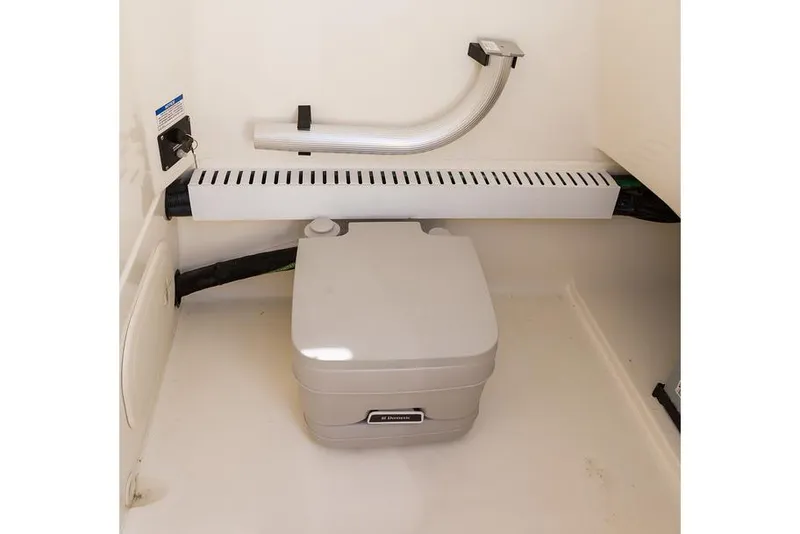 Slide: The Image of Manufacturer Provided Image: Boston Whaler 230 Outrage 2025 boat interior with portable toilet. - 16