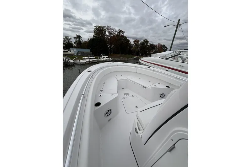 Slide: The Image of 2024 Sportsman Heritage 231 Center Console boat docked under cloudy skies. - 3