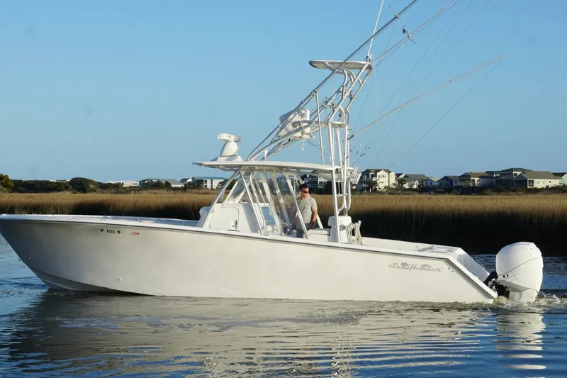 Slide: The Image of 2017 SeaHunter 35 Tournament boat cruising on calm water near coastal homes. - 12