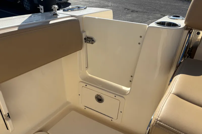 Slide: The Image of 2023 Scout 277 LXF boat interior with beige seating and storage compartment. - 11