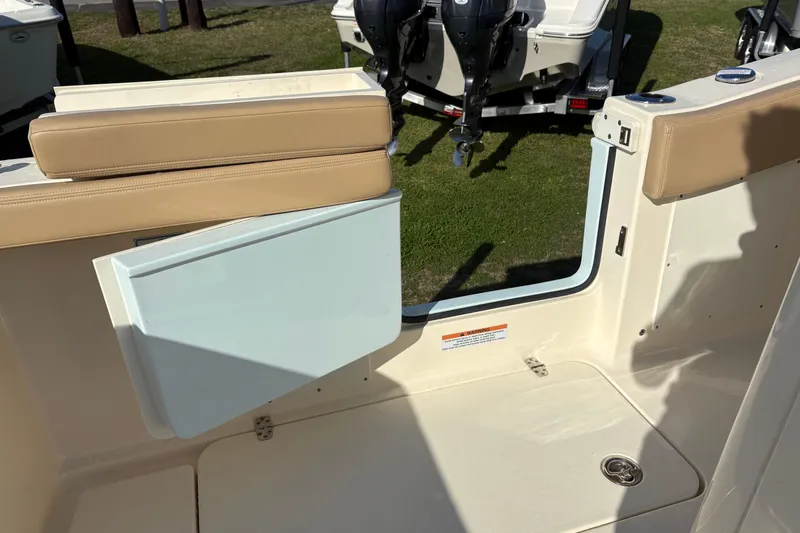 Slide: The Image of 2023 Scout 277 LXF boat interior with tan seating and open door. - 12