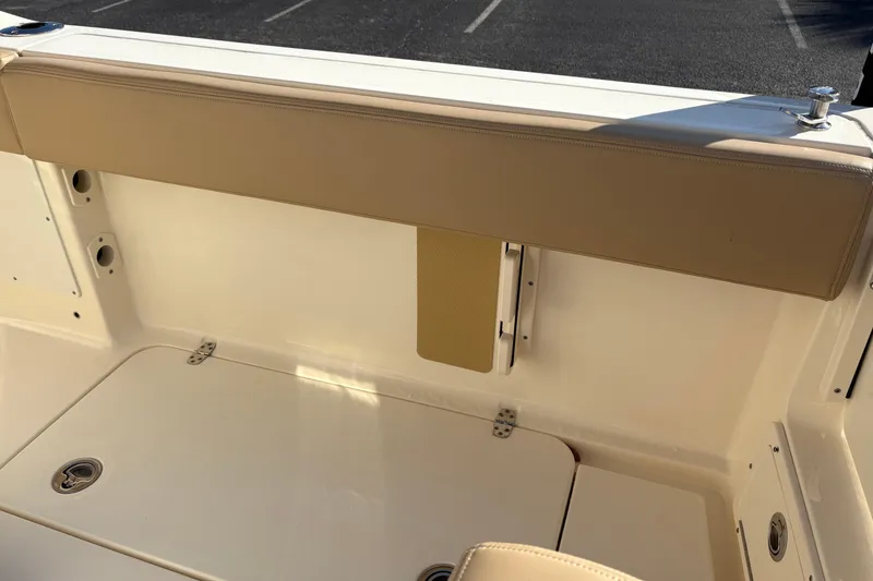 Slide: The Image of 2023 Scout 277 LXF boat interior with tan seating and storage compartment. - 13