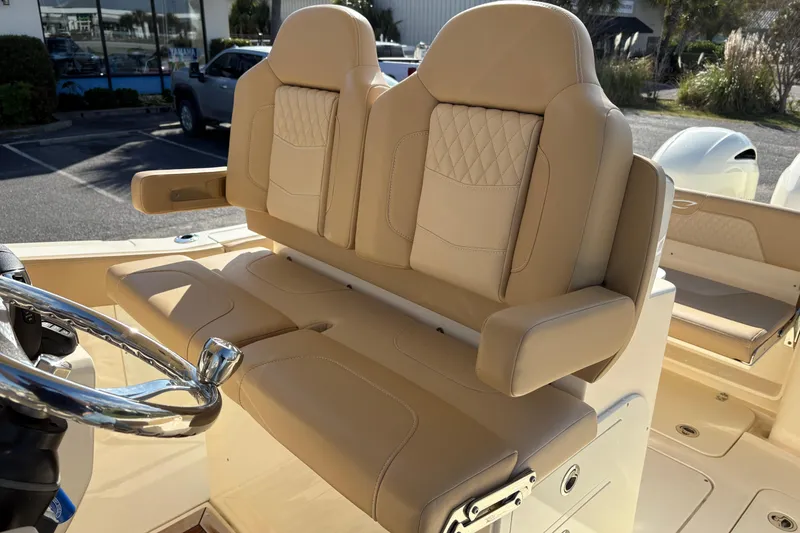 Slide: The Image of Luxurious seating on 2023 Scout 277 LXF boat with beige upholstery and steering wheel. - 16