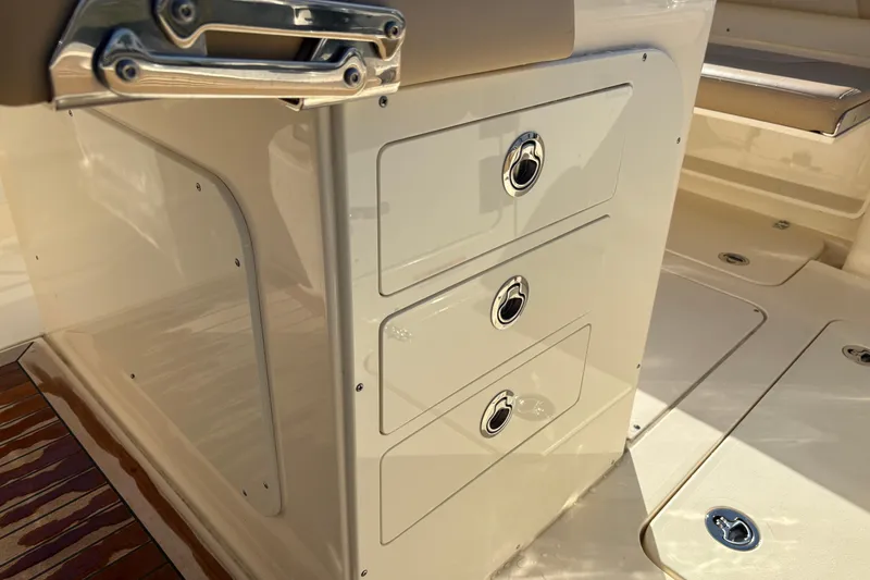 Slide: The Image of 2023 Scout 277 LXF boat interior with sleek storage drawers and polished metal handles. - 22