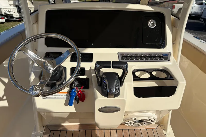 Slide: The Image of 2023 Scout 277 LXF boat dashboard with steering wheel and controls. - 25