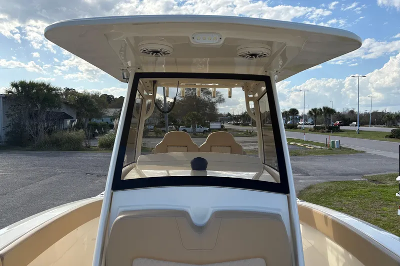 Slide: The Image of 2023 Scout 277 LXF boat with sleek design and spacious deck under a clear sky. - 33