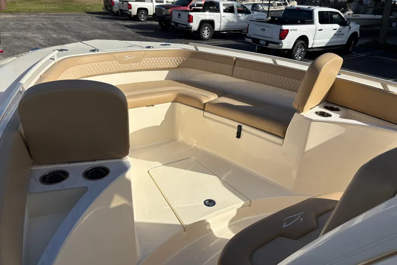 Slide: The Image of 2023 Scout 277 LXF boat interior with beige seating and cup holders. - 34