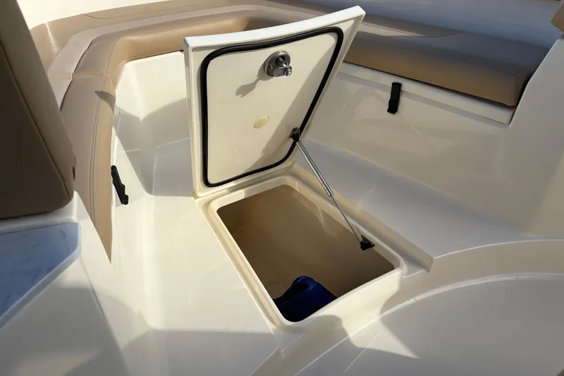 Slide: The Image of 2023 Scout 277 LXF boat storage compartment with open hatch and cushioned seating. - 35