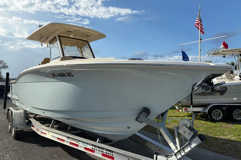 Slide: The Image of 2023 Scout 277 LXF boat on trailer, displayed outdoors under a clear sky. - 4