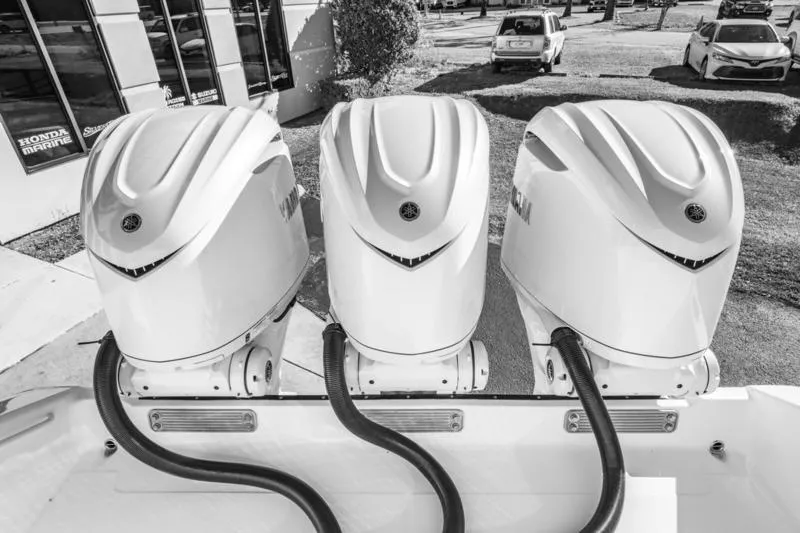 Slide: The Image of Triple outboard engines on a 2025 Edgewater 370CC boat, parked outdoors. - 21