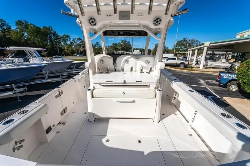 Slide: The Image of 2025 Edgewater 370CC boat interior with seating and storage, displayed outdoors. - 22