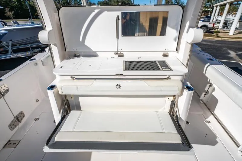 Slide: The Image of 2025 Edgewater 370CC boat interior with seating and grill station. - 28