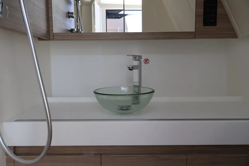 Slide: The Image of A modern bathroom with a glass sink and wood paneling on a Saxdor 400 GTO boat. - 41