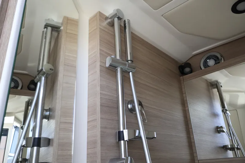 Slide: The Image of Modern shower fixtures in a sleek bathroom with wood paneling and mirrors. - 43