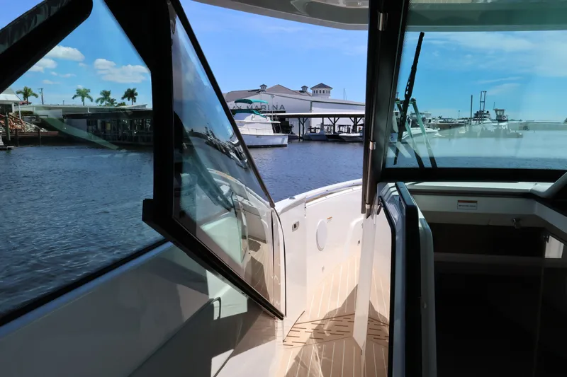 Slide: The Image of A modern boat with glass windows and an open deck, docked at a marina. - 44