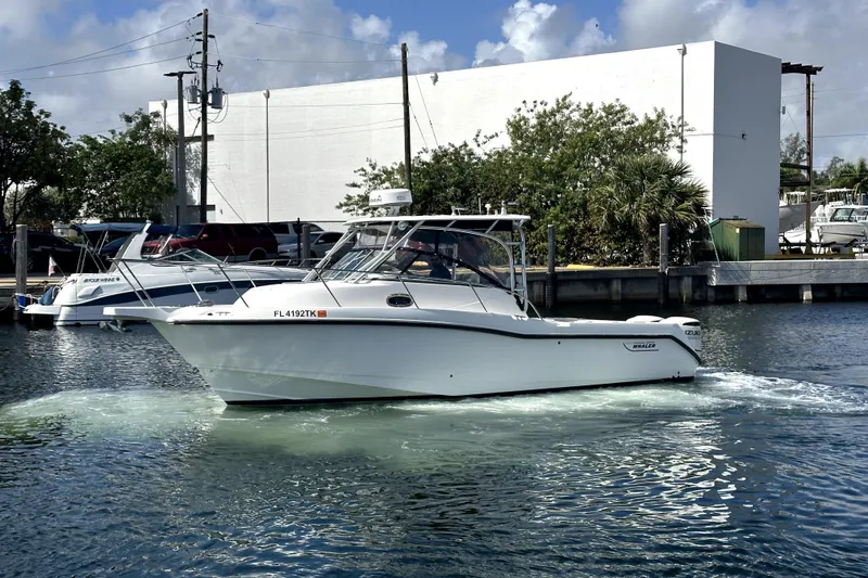 Slide: The Image of 2006 Boston Whaler 285 Conquest boat cruising in a marina with clear skies. - 10
