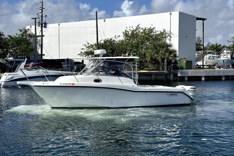 Slide: The Image of 2006 Boston Whaler 285 Conquest boat on water, dockside view. - 11
