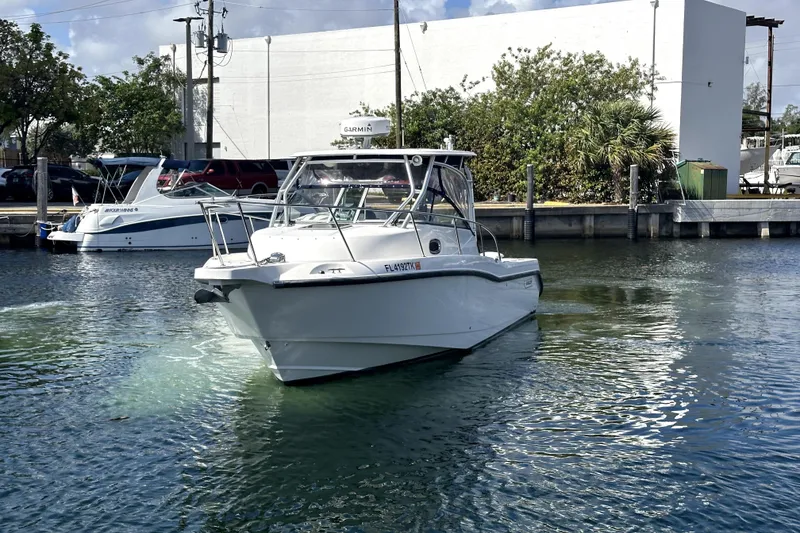 Slide: The Image of 2006 Boston Whaler 285 Conquest boat on water near dock, sunny day. - 18