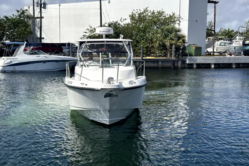 Slide: The Image of 2006 Boston Whaler 285 Conquest boat docked in a marina, front view. - 2