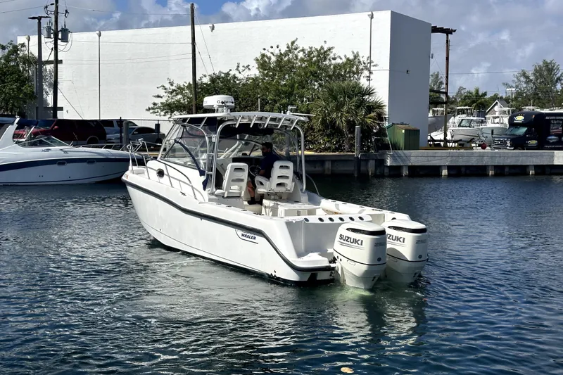 Slide: The Image of 2006 Boston Whaler 285 Conquest boat with twin Suzuki engines on the water. - 22