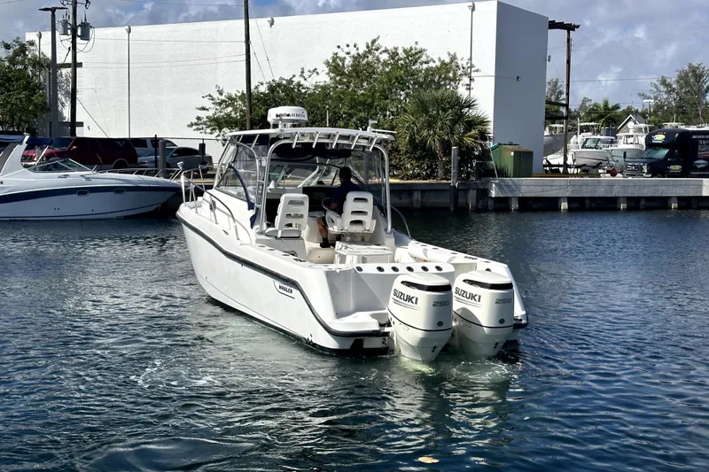 Slide: The Image of 2006 Boston Whaler 285 Conquest boat with twin Suzuki engines in marina. - 23