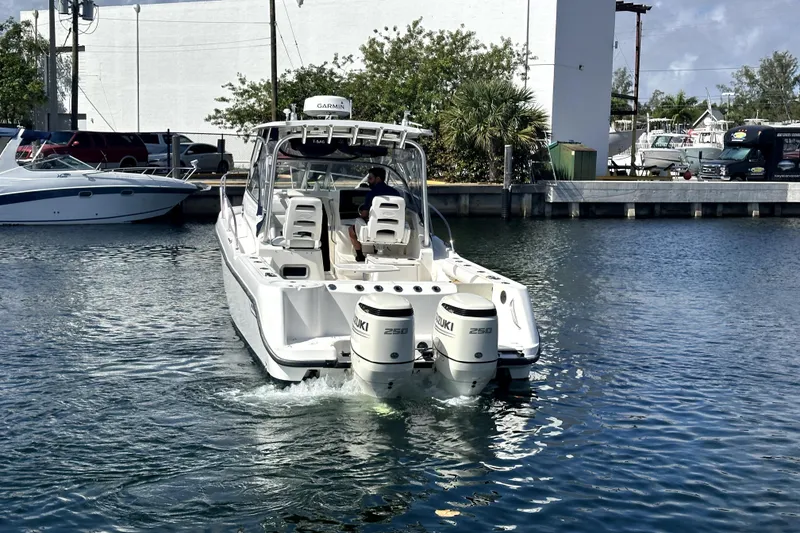 Slide: The Image of 2006 Boston Whaler 285 Conquest boat with twin Suzuki engines in a marina. - 25
