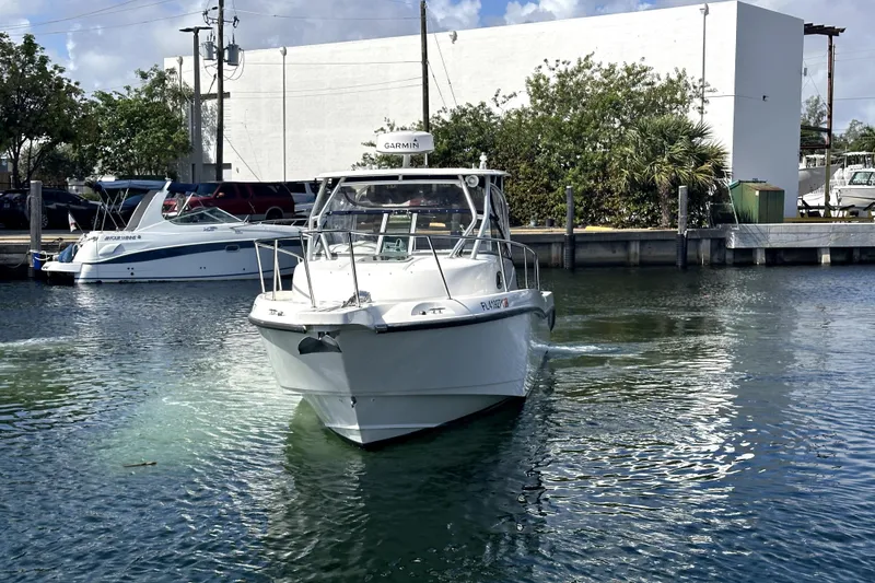 Slide: The Image of 2006 Boston Whaler 285 Conquest boat on water near dock, sunny day. - 3