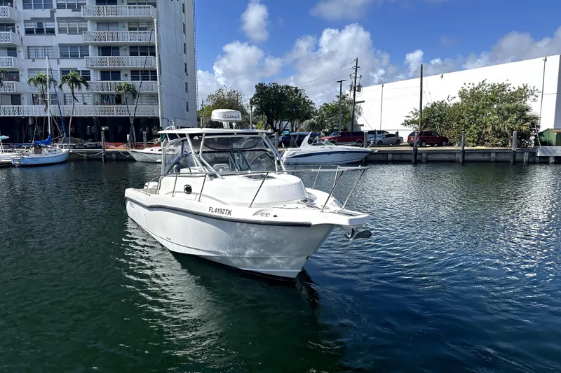 Slide: The Image of 2006 Boston Whaler 285 Conquest boat docked in a marina, clear sky background. - 30